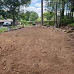 Backyard hardscape construction project with leveled ground and base work