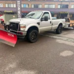 Commercial property snow removal truck in action during winter storm