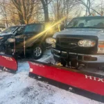 Heavy-duty snow plow truck removing snow from residential driveway