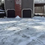 Driveway cleared after heavy snowfall with professional snow plowing equipment